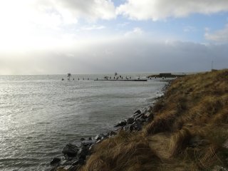 Ebbe und Flut auf Vlieland | Havenmond van de
waddenhaven op Vlieland staat onder water: alleen de toppen van
de palen van het remmingwerk zijn nog zichtbaar
Ebbe und Flut auf Vlieland